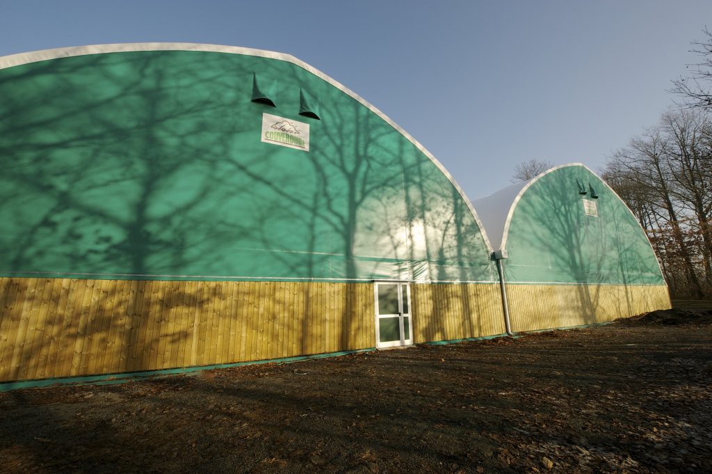 Court de tennis couvert par une couverture textile sur portiques en bois lamellé-collé – vue extérieure – Maine-et-Loire (49)