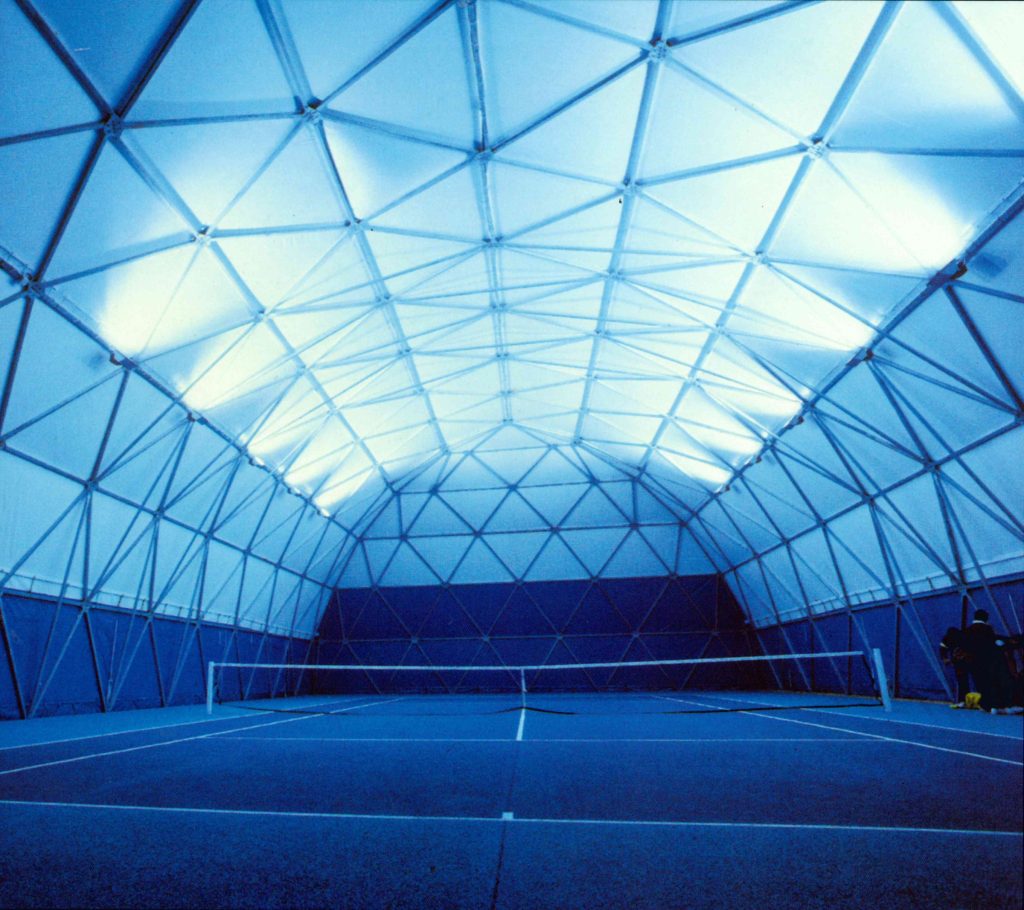 Court de tennis couvert par une structure textile géodésique – éclairage de nuit